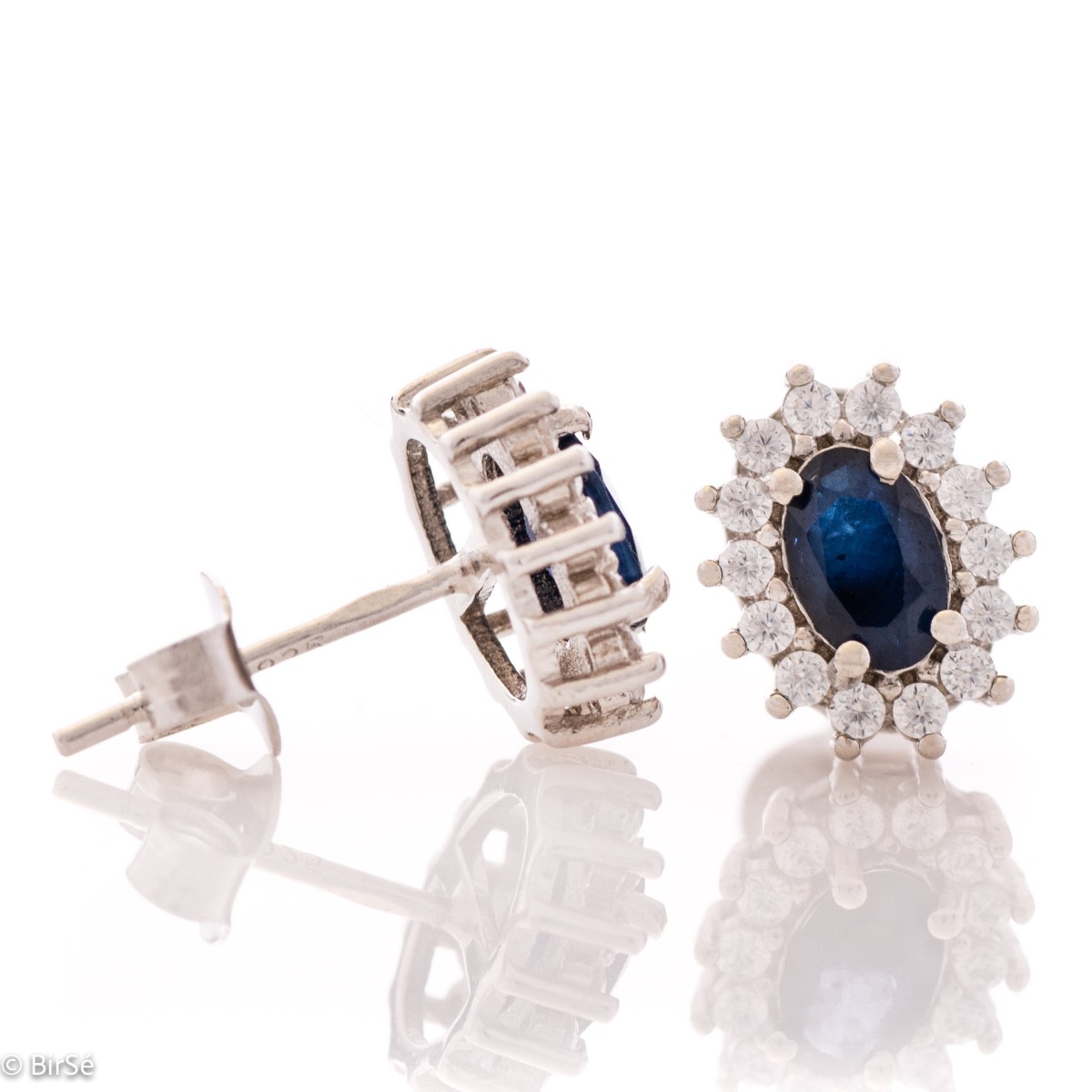 Delicate and radiant women's stud earrings with exquisite workmanship combining a unique natural sapphire, surrounded by sparkling zircons, with rhodium-plated silver. They can be combined with a ring, necklace and bracelet of the same model.