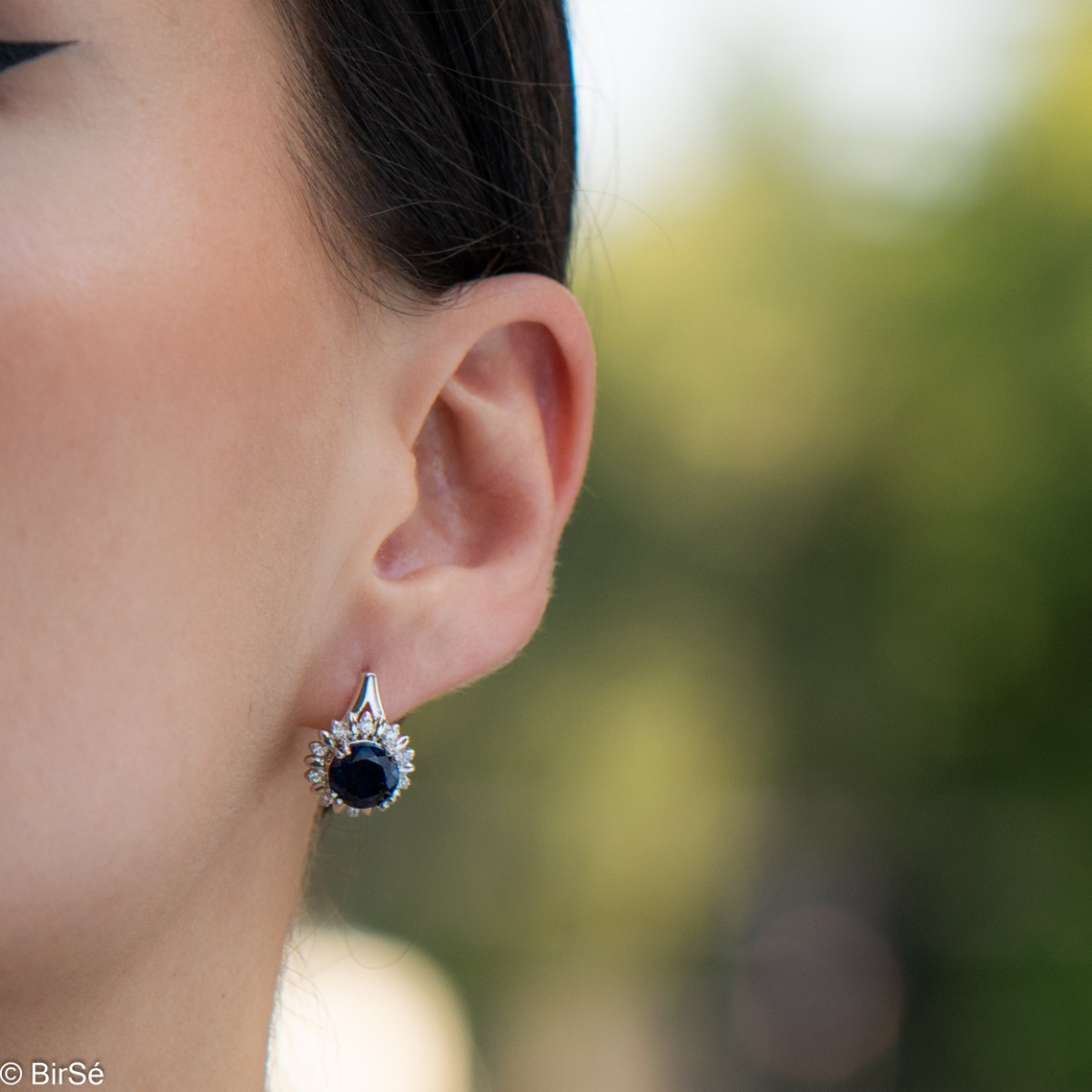 Extremely elegant ladies' earrings with English fastening and precise craftsmanship combining rhodium-plated silver with radiant natural sapphire and sparkling zircons. They can be combined with a pendant and a ring of the same model.