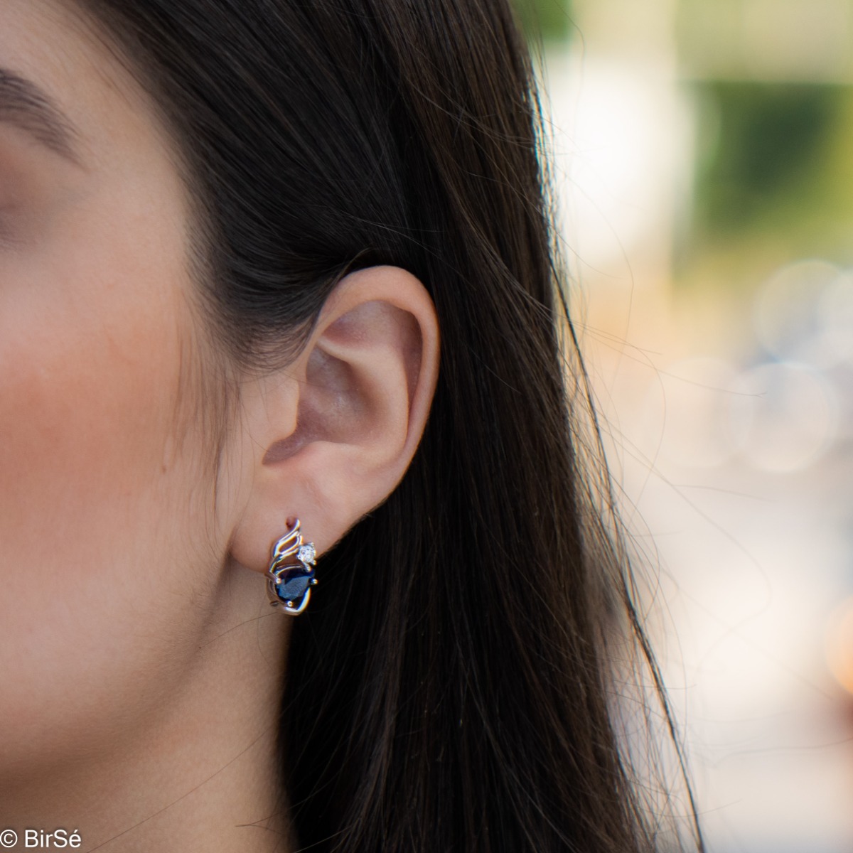 Radiant women's earrings with English clasp and a delicate combination of beautiful rhodium silver with a charming natural sapphire stone, in an exquisite teardrop shape, complemented by the sparkle of zircon.