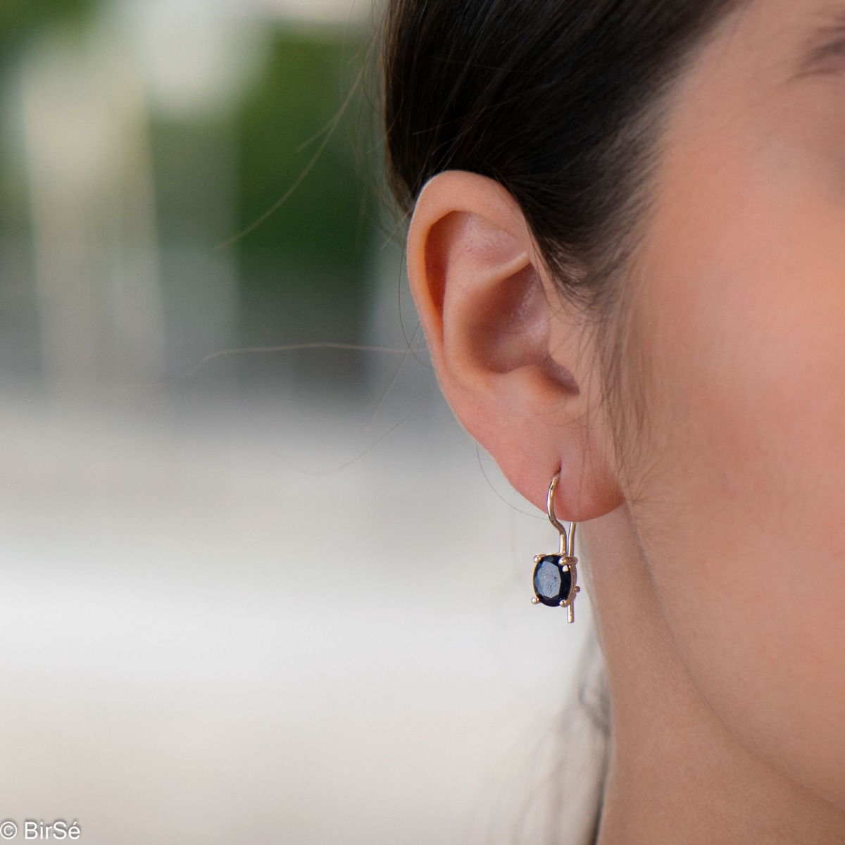 Delicate women's earrings with a clean and precise design combining shiny rhodium silver with radiant natural sapphire.