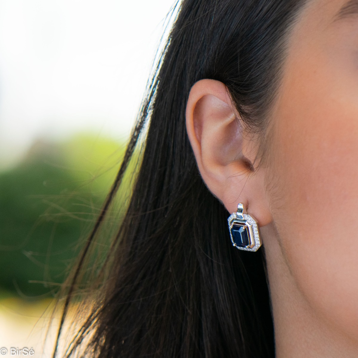 Elegant women's earrings with English clasp and precision craftsmanship entirely of rhodium-plated silver, combined with radiant natural sapphire and sparkling zircons. They can be combined with a ring and pendant of the same model.