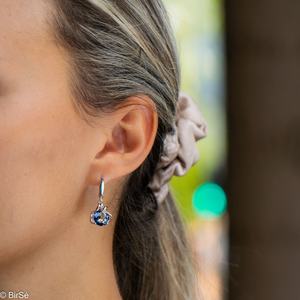 Exquisite earrings with an English clasp and a spectacular combination of soft rhodium silver with a radiant natural blue mystic topaz, enveloped in extraordinary curves.