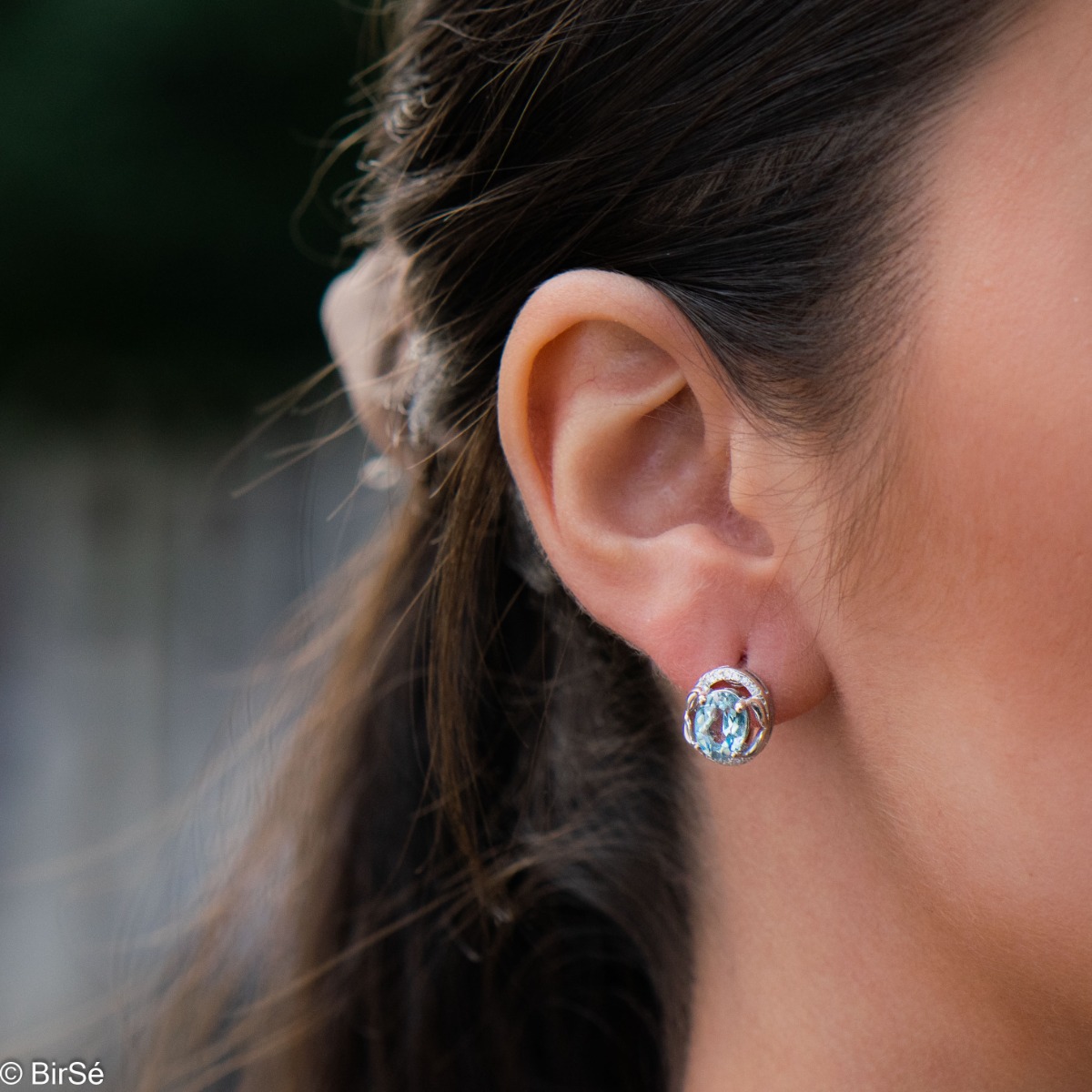 A royal vision - elegant silver earrings with a delicate design. Stylish composition made of fine combination of rhodium silver with sparkling zircon stones and exquisite blue topaz. In a lovely set with a ring from the model.