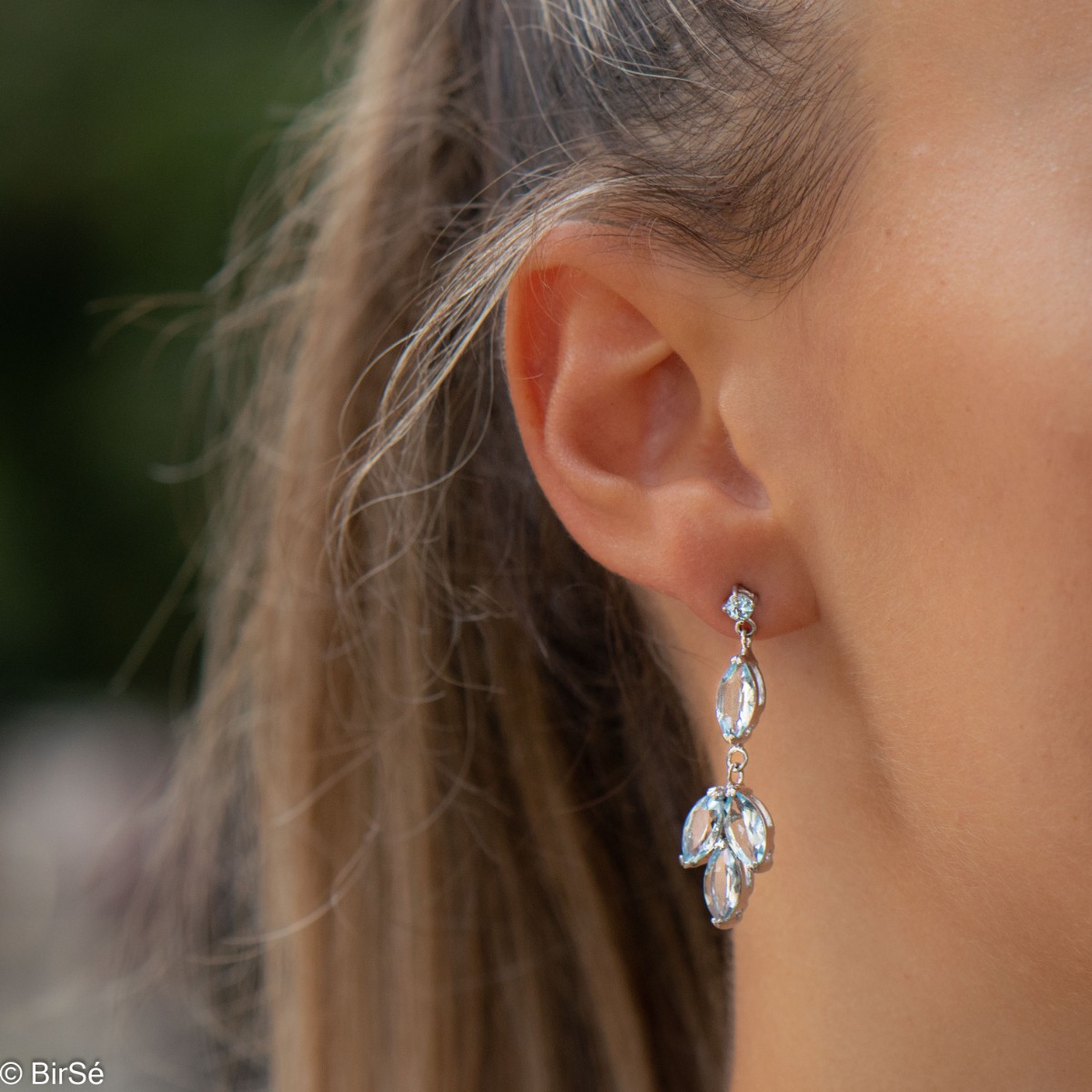 Elegantly crafted drop earrings of divinely beautiful blue topazes. The earrings are made of rhodium-plated silver, which, combined with the captivating topaz, will light up your face and give you a regal glow.