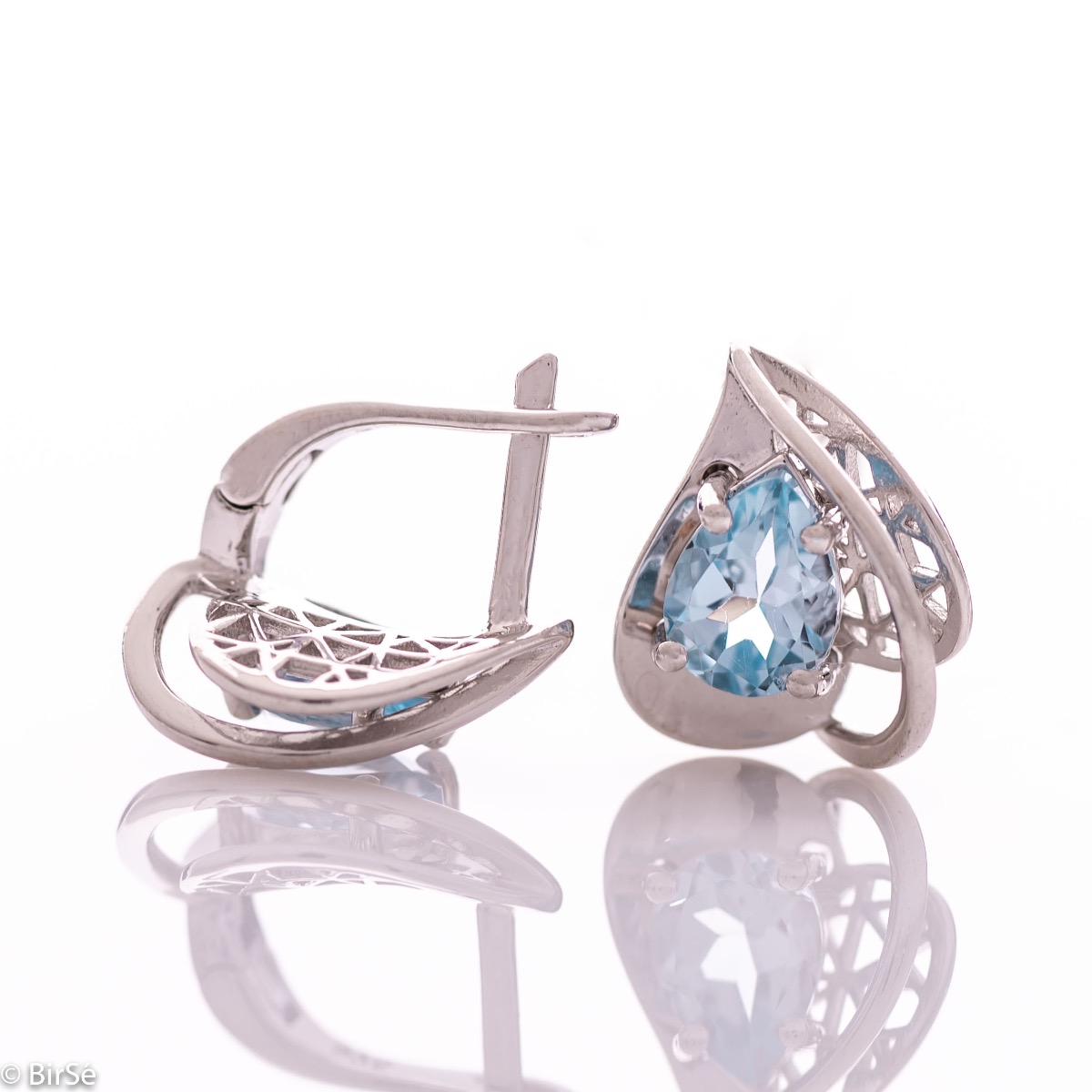 Spectacular ladies' earrings with English clasp and delicate heart-like shape, combined with radiant natural blue topaz and rhodium-plated silver. It can be combined with a pendant and a ring of the same model.