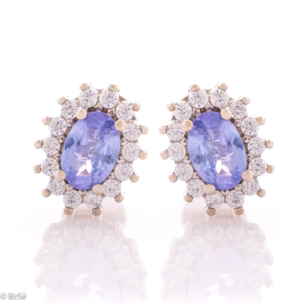 Delicate and radiant women's stud earrings with exquisite workmanship combining a unique natural tanzanite, surrounded by sparkling zircons, with rhodium-plated silver. They can be combined with a ring, necklace and bracelet of the same model.