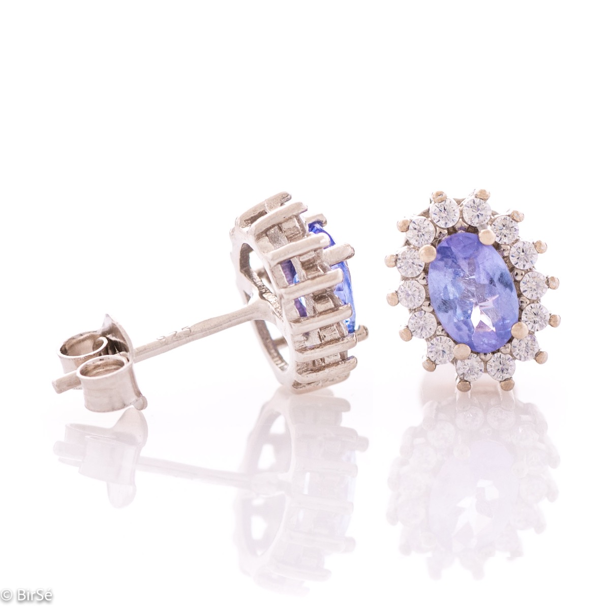 Delicate and radiant women's stud earrings with exquisite workmanship combining a unique natural tanzanite, surrounded by sparkling zircons, with rhodium-plated silver. They can be combined with a ring, necklace and bracelet of the same model.