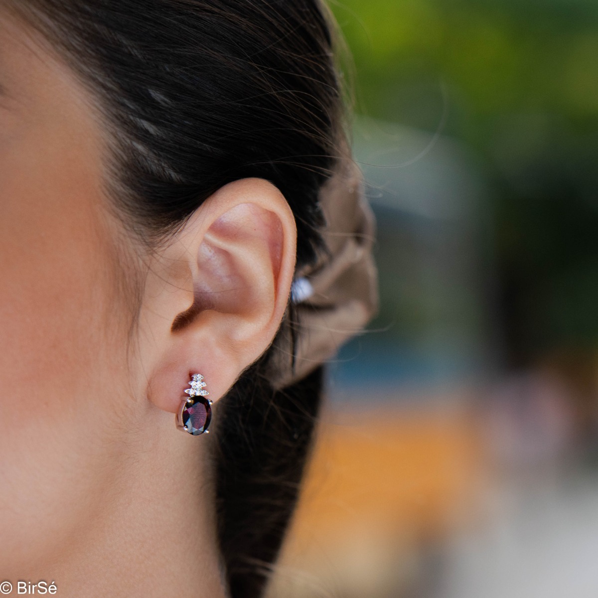 Elegant women's earrings with English clasp and delicate craftsmanship entirely of rhodium-plated silver, combined with radiant natural garnet and sparkling zircons. They can be combined with a ring and pendant of the same model.