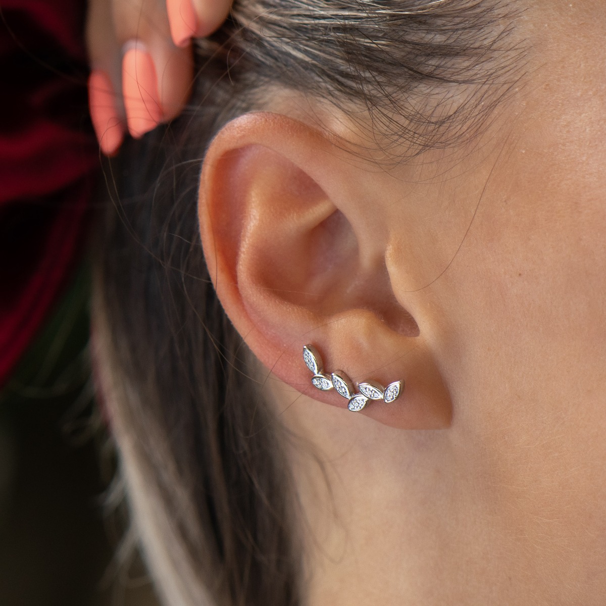 Delicate earrings of fine rhodium silver, with masterly shaped petals of glittering zircons.