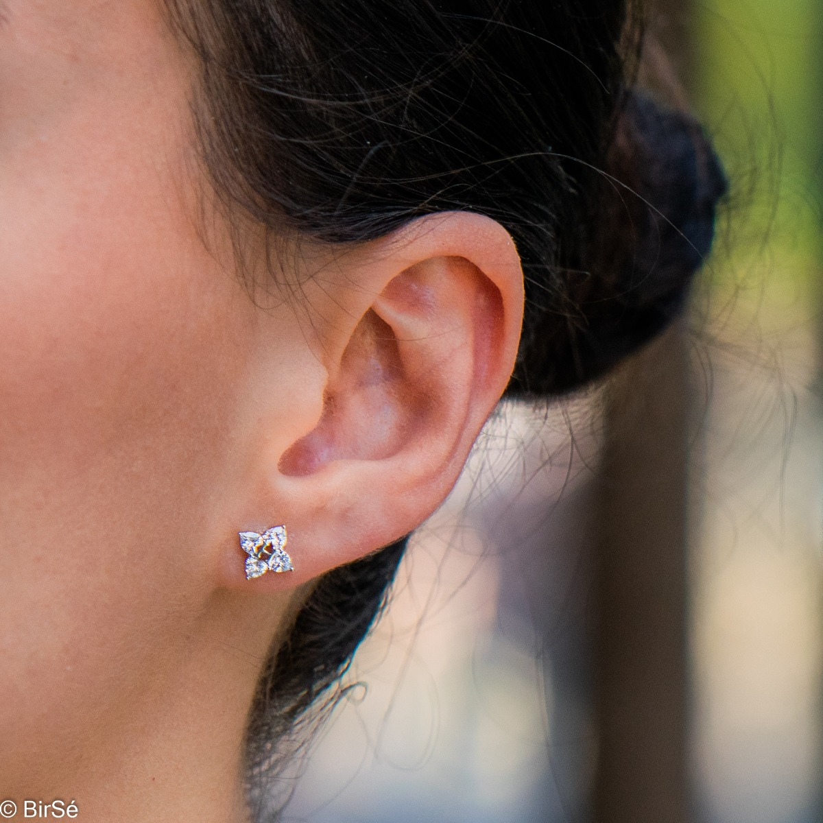 Captivating silver earrings with a charming design of soft silver, delicately forming a flower. The added sparkling heart-shaped zircons form the petals and enhance the beauty of the jewelry. Pin fastening.