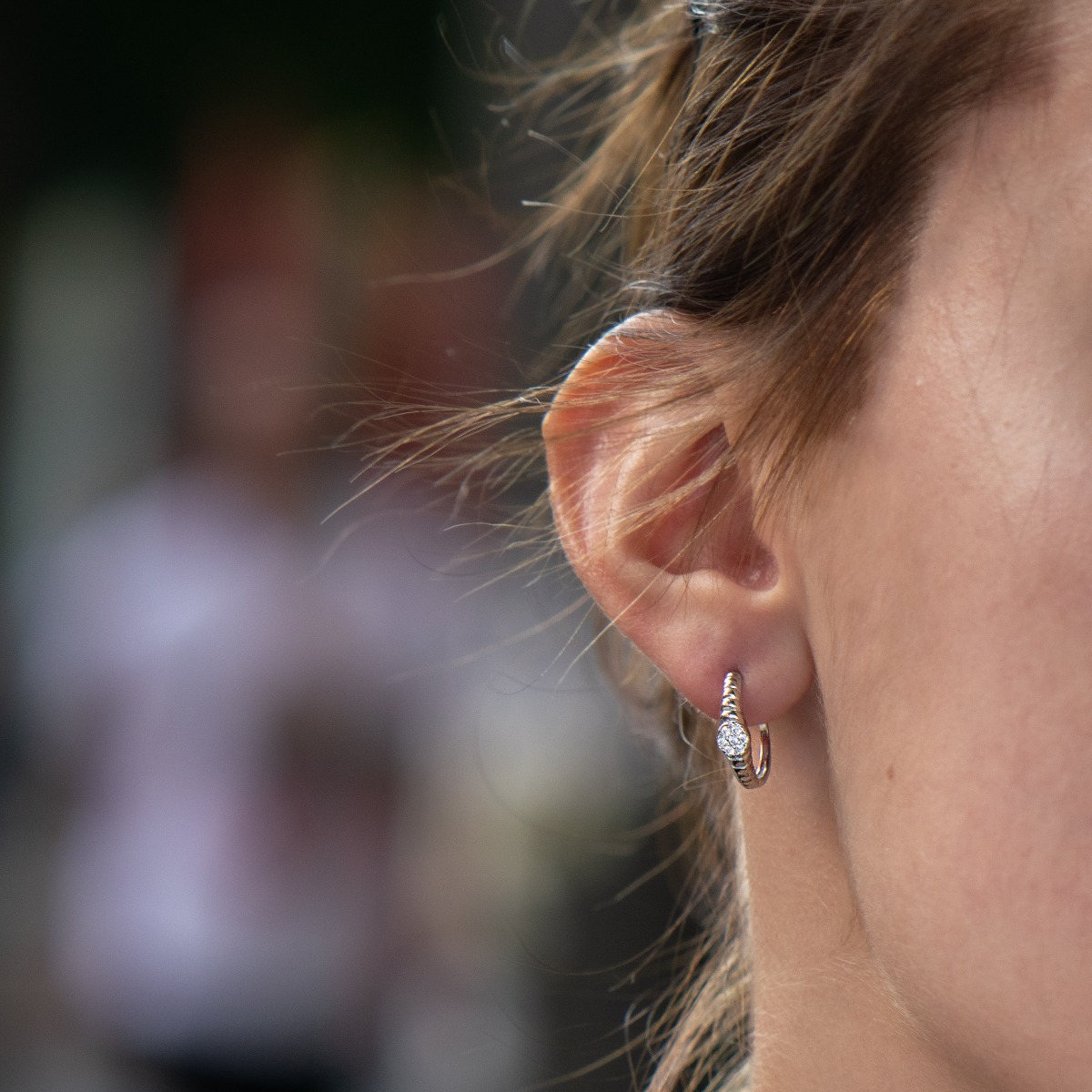 Elegant women's earrings made entirely of fine rhodium-plated silver in the shape of a half-ring. Stylishly decorated with fine zircons, and the fastening is with a pin.