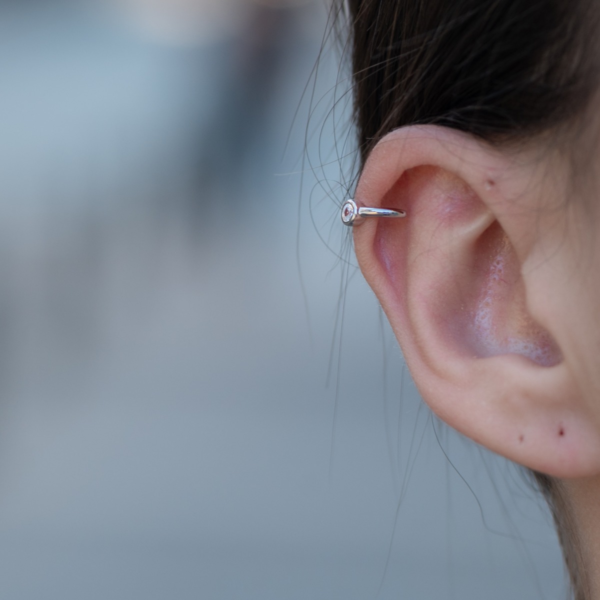 Delicate women's earrings with fine craftsmanship in rhodium-plated silver, decorated only with one exquisite zircon. The earrings are designed to attach to the cartilage of the ear without the need for piercing.