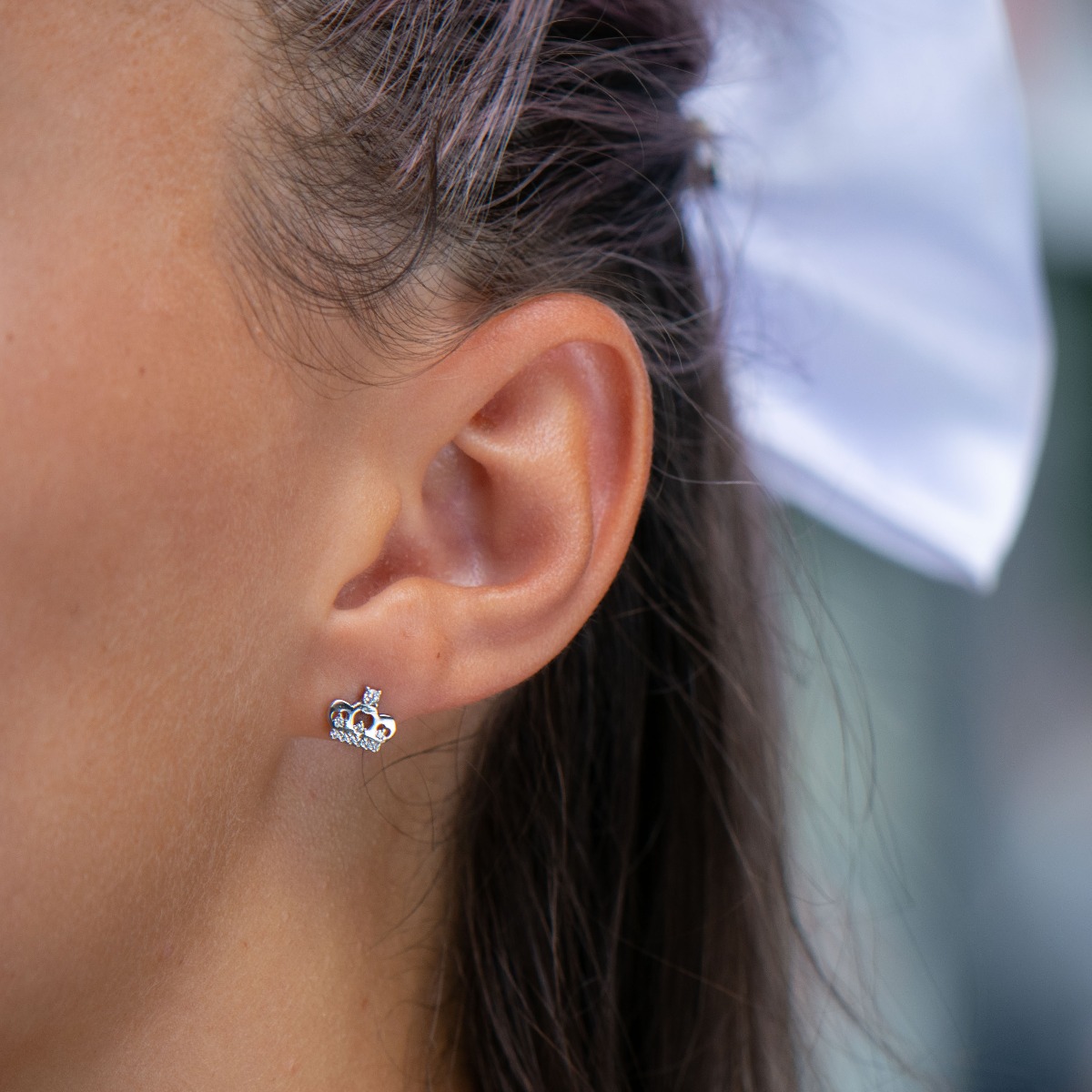 Charming women's stud earrings in the shape of beautiful crowns, complemented by sparkling fine cubic zirconias and crafted entirely in rhodium silver.