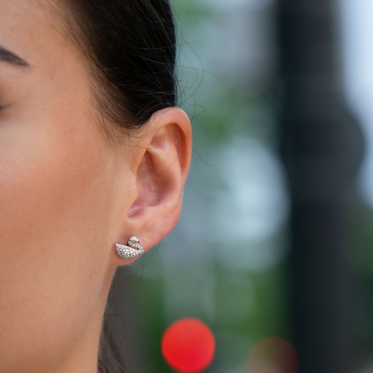 Delicate and glamorous women's stud earrings with an exquisite swan shape, complemented by fine zircons and made entirely of rhodium-plated silver. Suitable for small and large ladies.