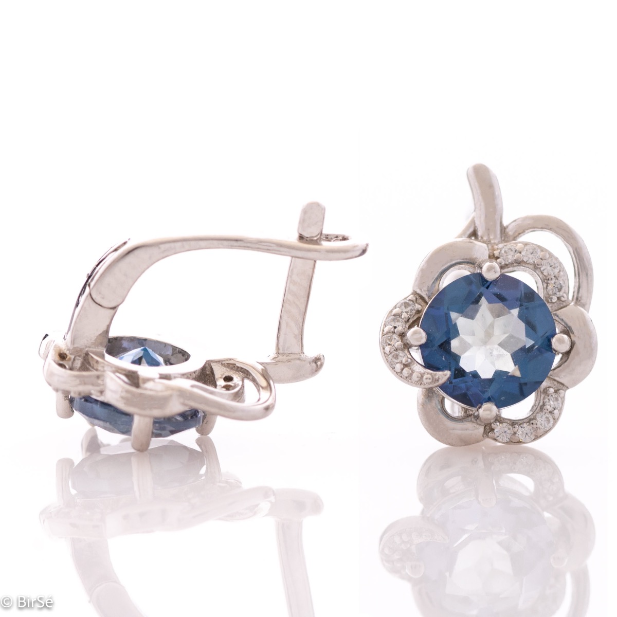 Delicate ladies earrings with English clasp and charming natural blue mystic topaz stone, surrounded by beautiful curves and sparkling zircons. Exquisite workmanship entirely in rhodium-plated silver with a spectacular ring and pendant set.