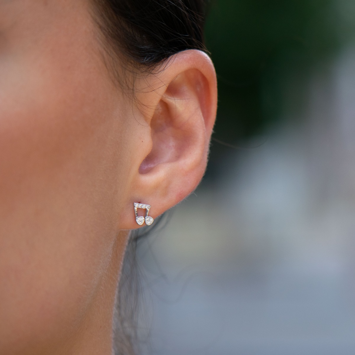 Delicate women's earrings made of fine rhodium silver, with an interesting design layout in a musical style. Beautiful notes, exquisitely decorated with glittering zircons, would make a suitable gift for any lady devoted to music. And the pin fastening is