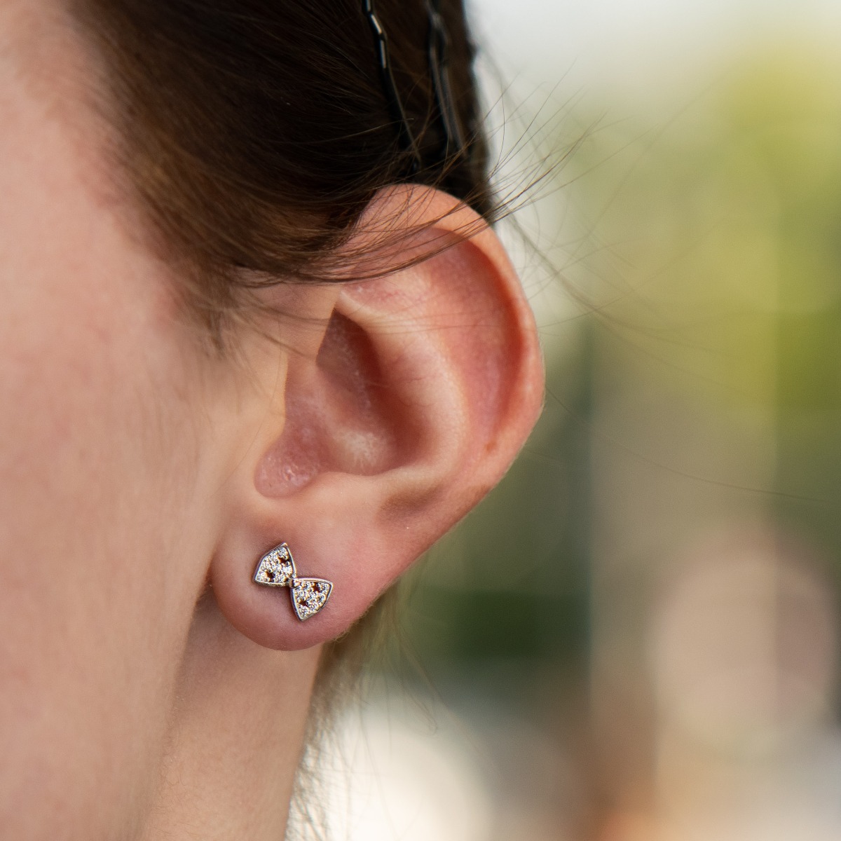 Brilliantly crafted delicate ribbon stud earrings with a charming design, all rhodium-plated silver studded with dazzling cubic zirconias.