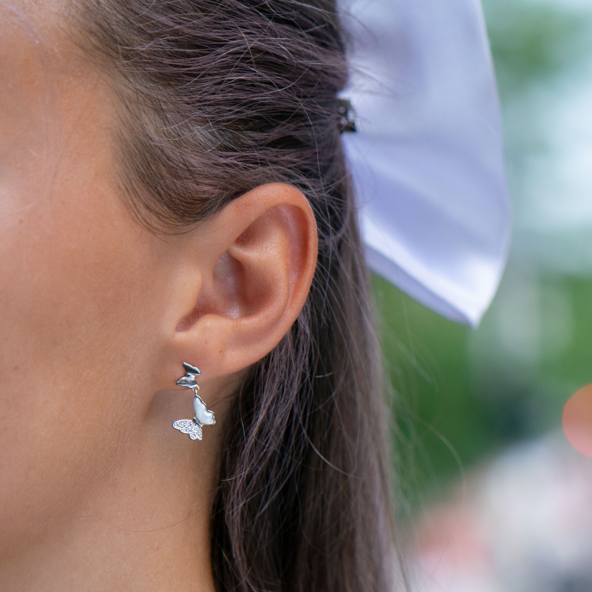 Elegant dangling earrings made entirely of rhodium-plated silver with lovely butterflies, spectacularly decorated with zircons and mother-of-pearl. The fastening is with a pin, for a more elegant look of the jewelry.