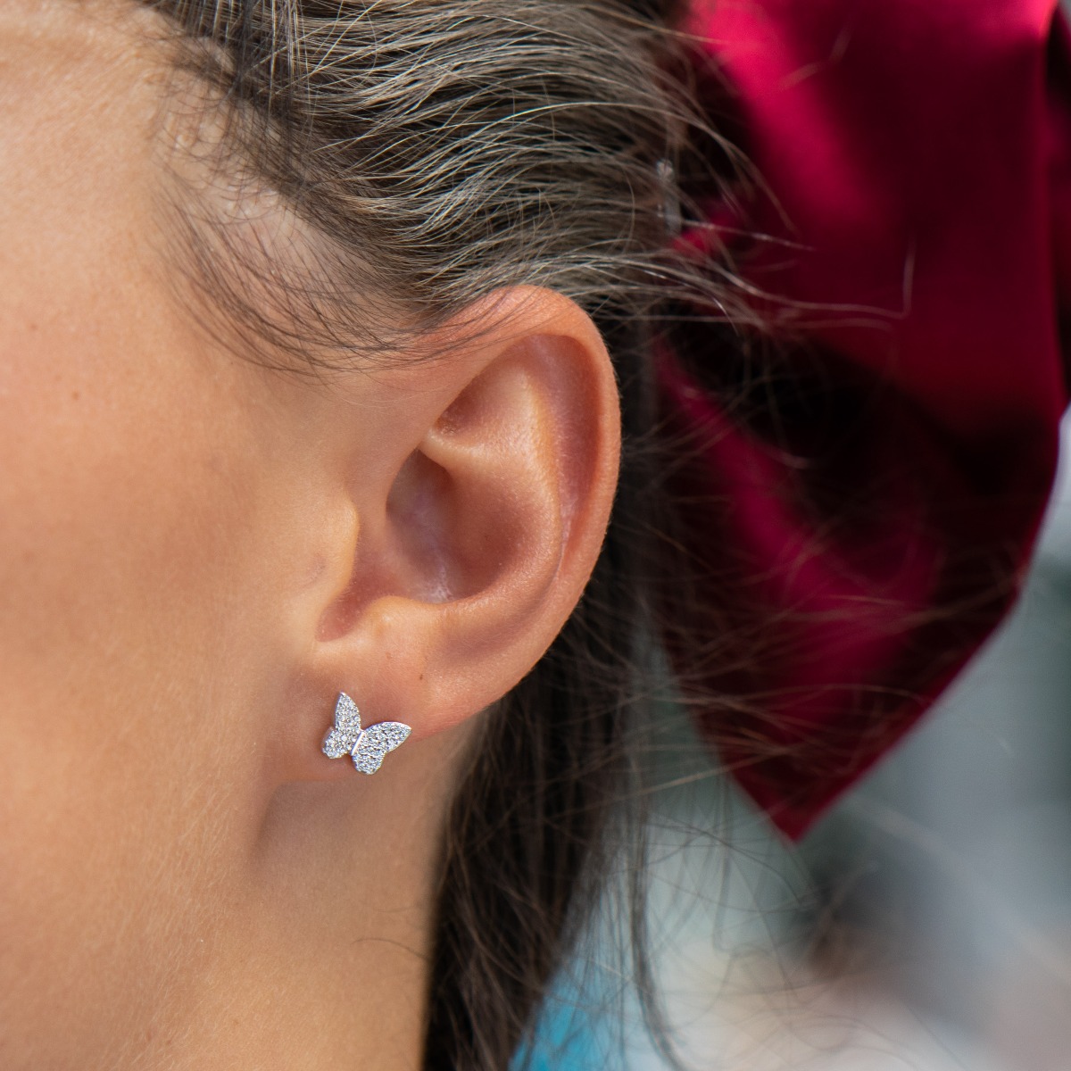 Delicate women's earrings in fine rhodium silver, with a designer shaped butterfly studded with sparkling zircons. The earrings are fastened with a pin - extremely convenient and secure. A suitable gift for the girl of your heart.