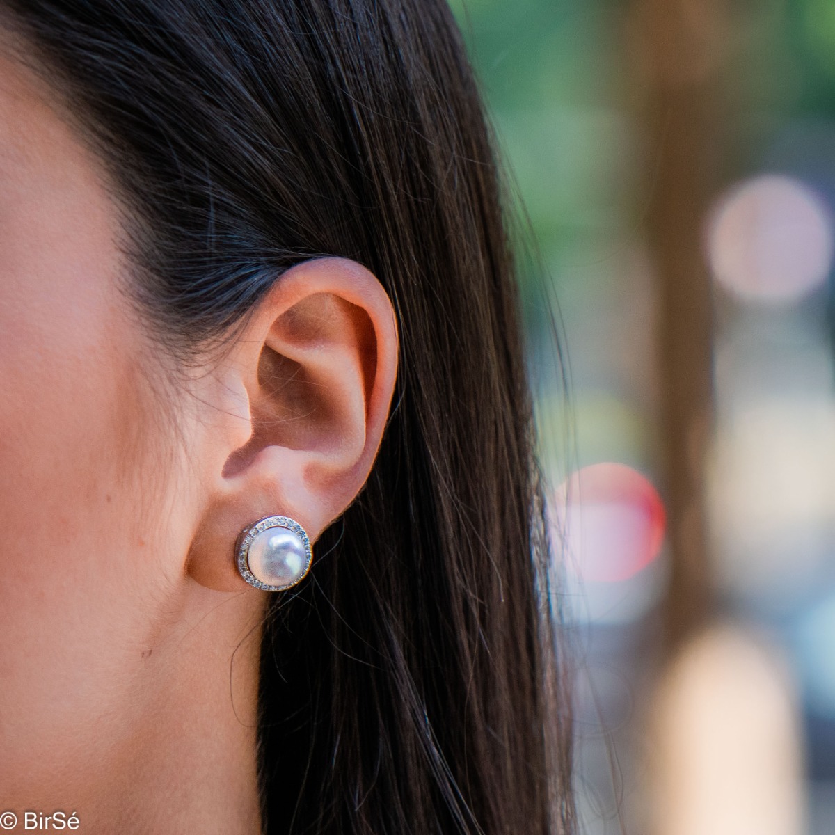 Stylish women's earrings, exquisitely crafted from fine rhodium silver. A captivating natural pearl is at the base of the earrings, charmingly surrounded by sparkling zircons. A suitable piece of jewelry for your special moments.