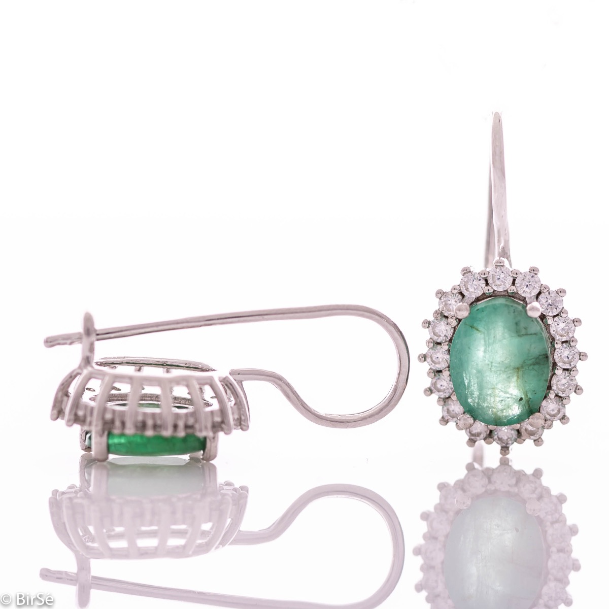 Exclusive women's earrings with exquisite workmanship combining delicate rhodium silver with a radiant natural emerald surrounded by sparkling zircons.