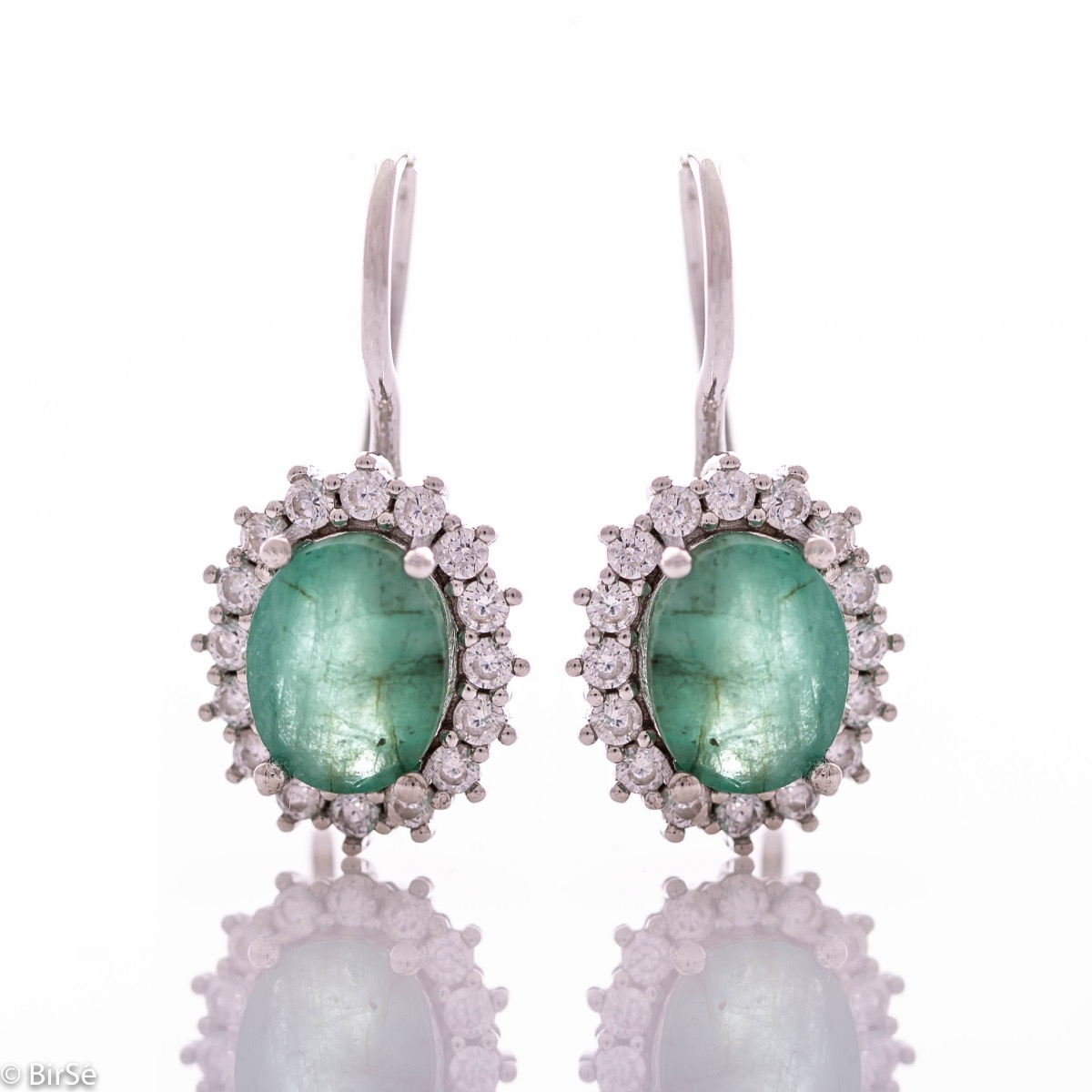 Exclusive women's earrings with exquisite workmanship combining delicate rhodium silver with a radiant natural emerald surrounded by sparkling zircons.