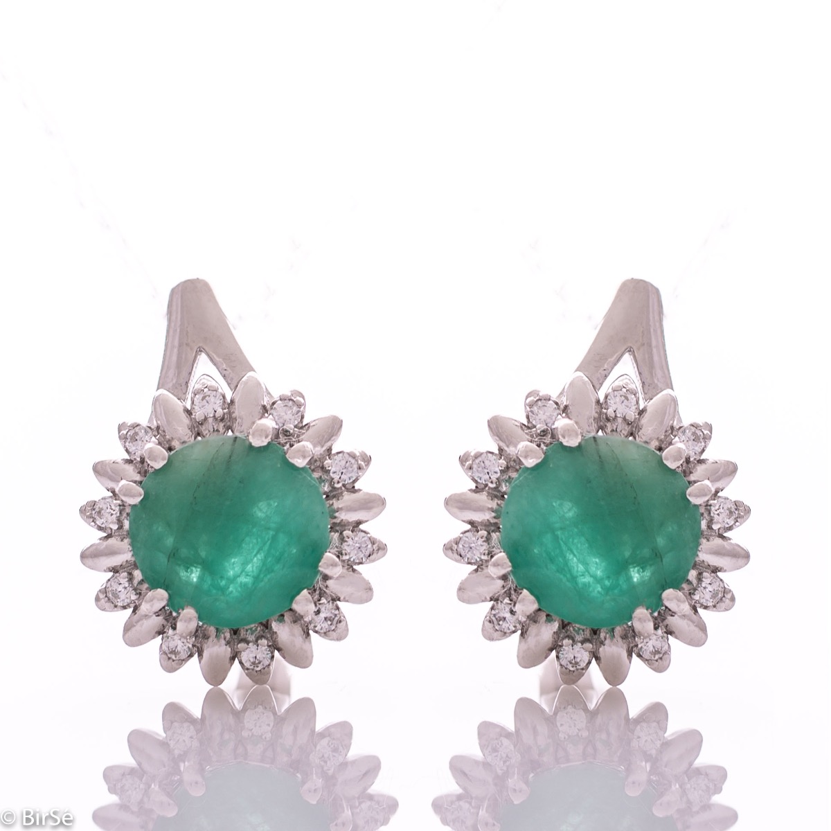 Extremely elegant ladies' earrings with English fastening and precise craftsmanship combining rhodium-plated silver with radiant natural emerald and sparkling zircons. They can be combined with a pendant and a ring of the same model.