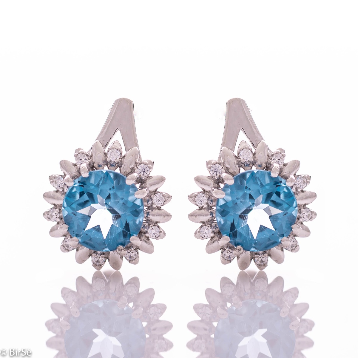 Extremely elegant ladies' earrings with English fastening and precise craftsmanship combining rhodium silver with radiant natural London topaz and sparkling zircons. They can be combined with a pendant and a ring of the same model.