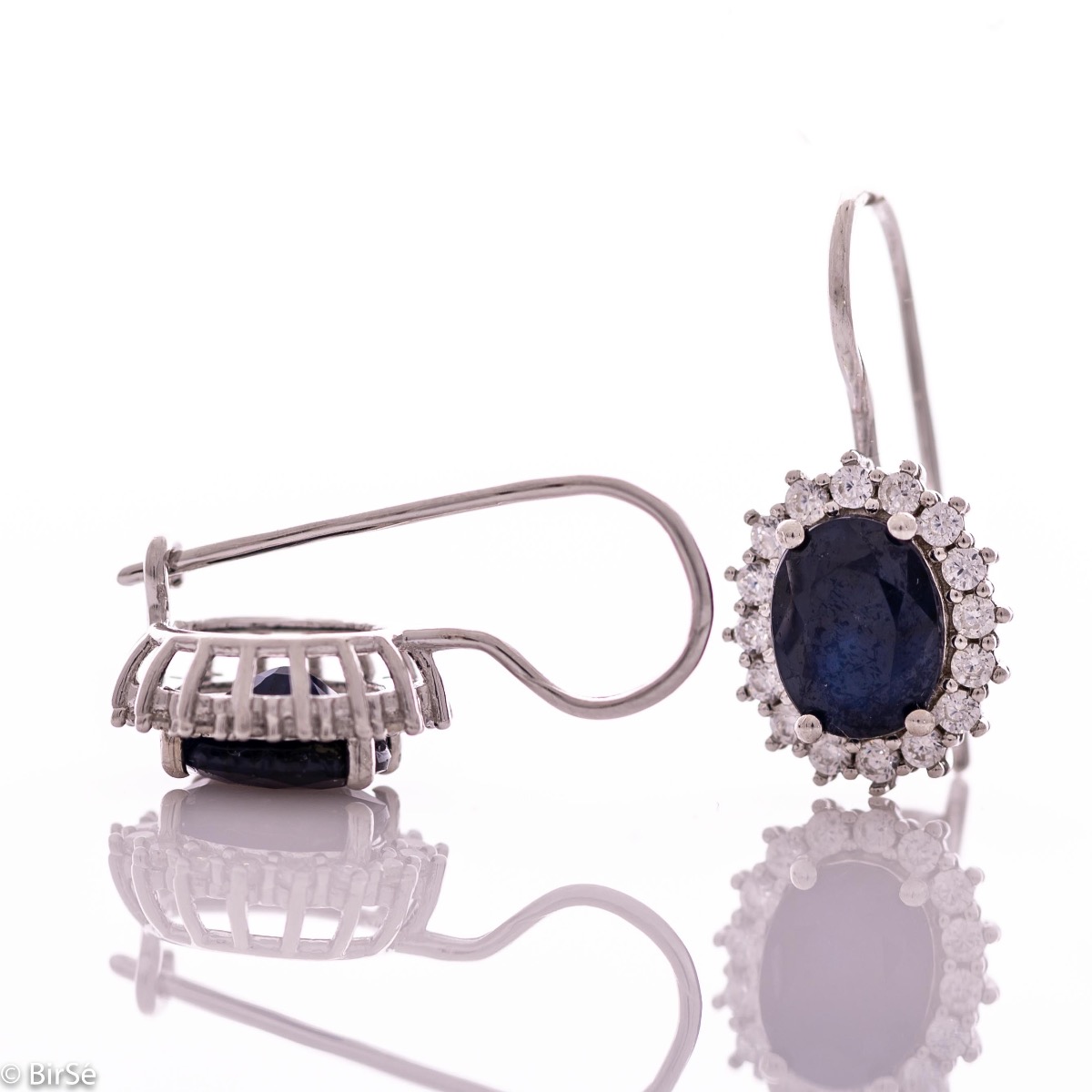 Exclusive women's earrings with exquisite workmanship combining delicate rhodium silver with a radiant natural sapphire surrounded by sparkling zircons.