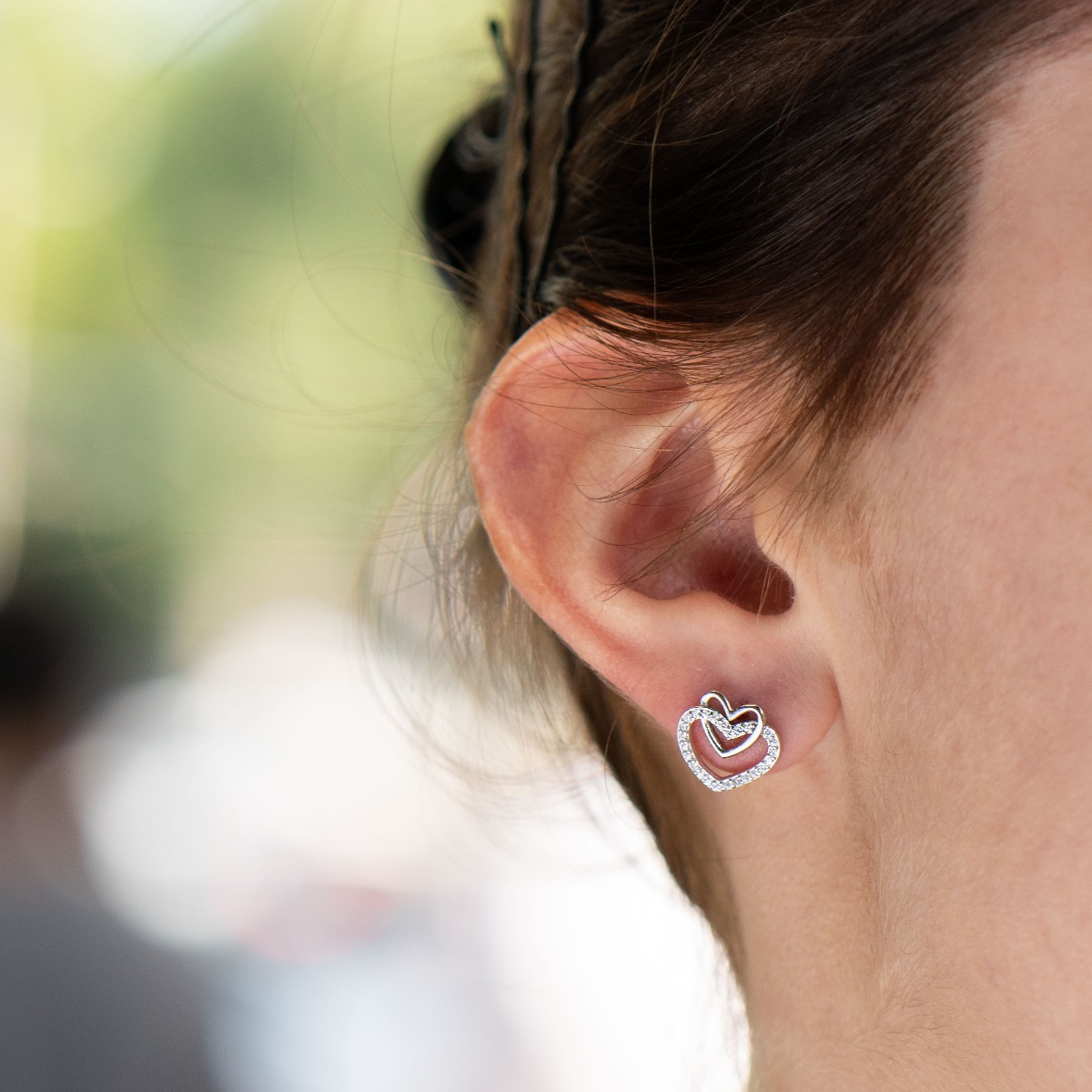 A charming model of women's earrings with an elegant design of intertwined hearts, completely formed by combining rhodium-plated silver with sparkling zircons. The fastening is with a pin - comfortable and practical. A beautiful look for your special mome