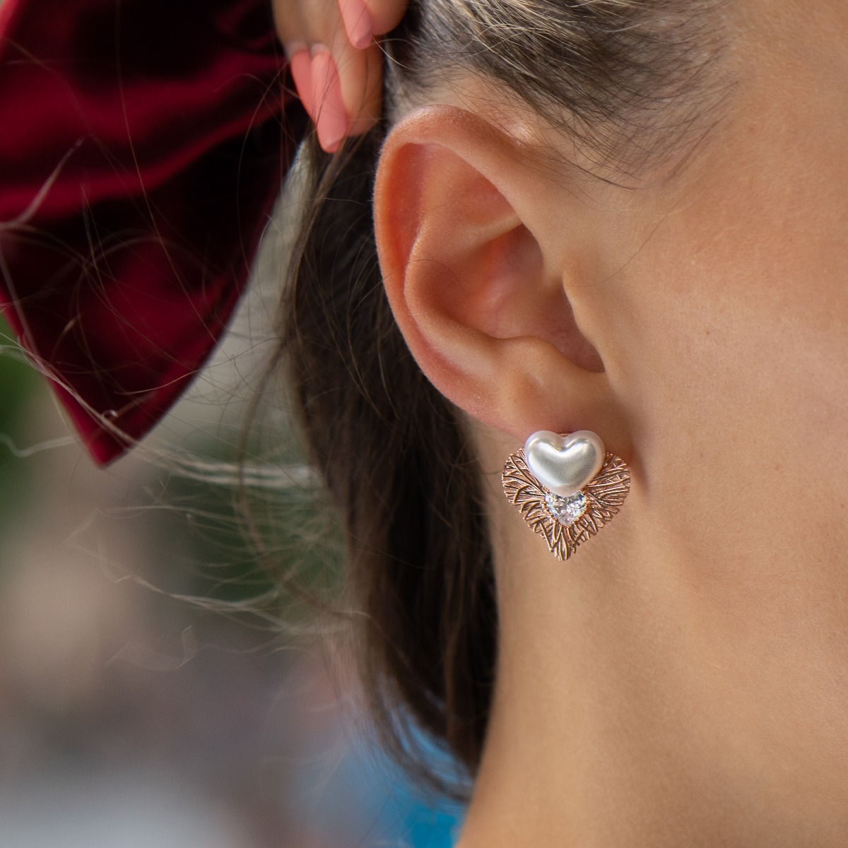 Longing and dreaming of love expressed in the new BirSe earrings. Crafted from fine rose silver, an openwork heart gently wraps around a smaller pearl heart. The jewelry is a suitable gift for the beloved woman.