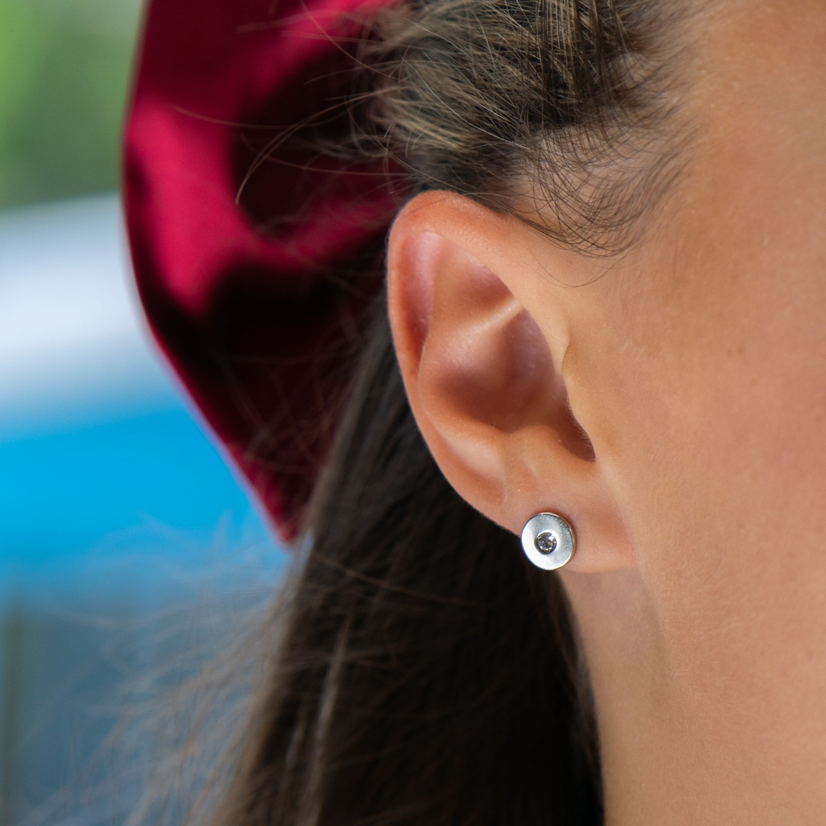 Delicate women's earrings in fine rhodium-plated silver, with an elegantly shaped circle, in the center of which charmingly sparkles a zircon. The earrings are fastened with a pin - extremely comfortable and practical. A suitable gift for any stylish lady