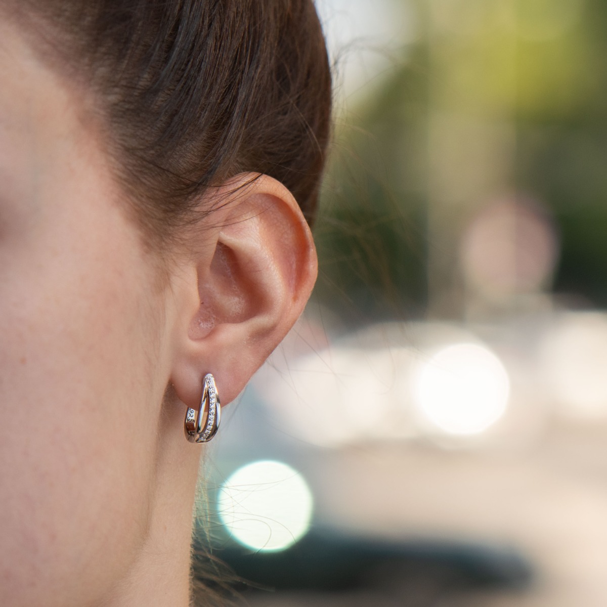 Elegant earrings with a stylish design, fine elements of rhodium-plated silver, decorated with sparkling zircons. The earrings have an English fastening - practical and secure.