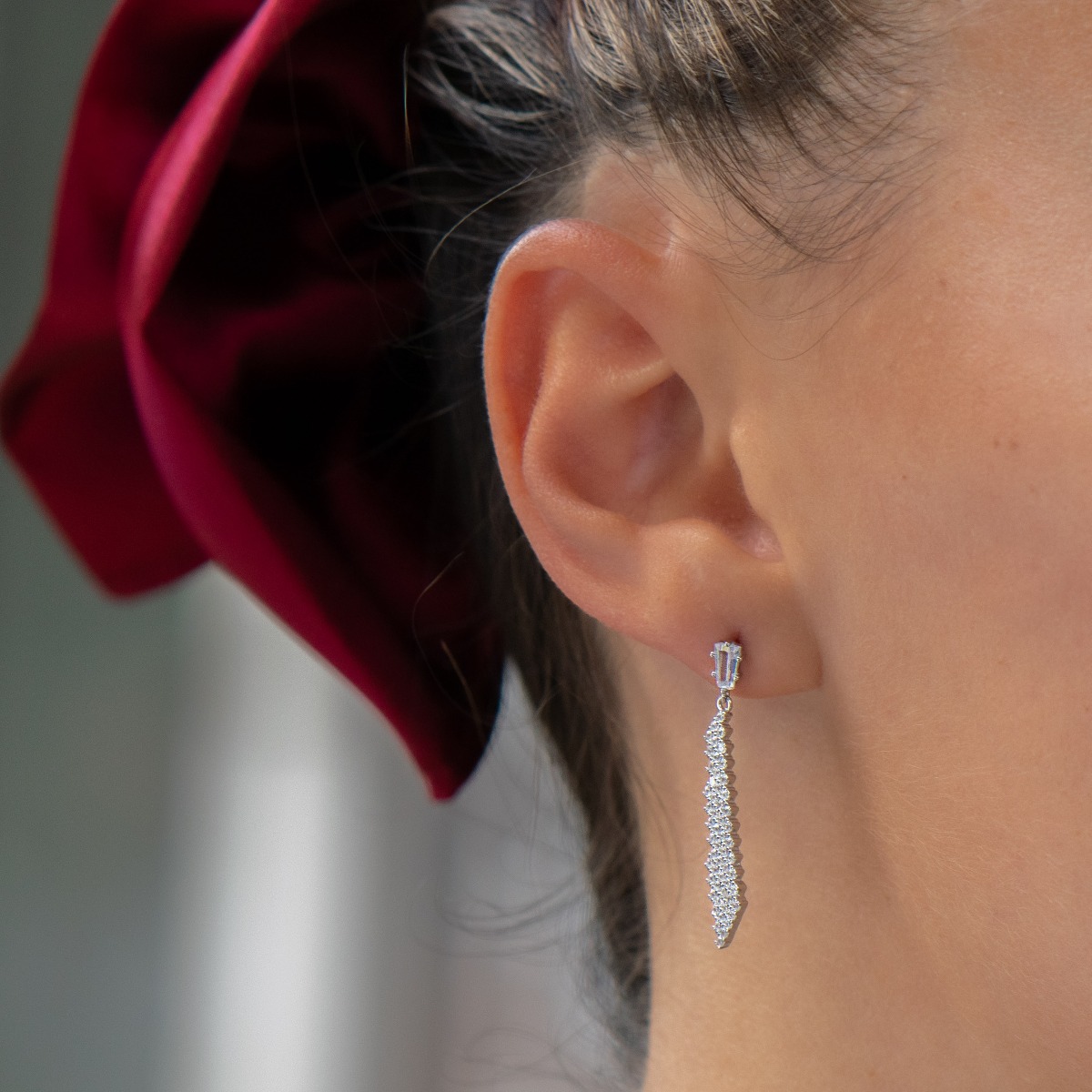 Elegant earrings with a stylish design - a fine mesh of rhodium-plated silver, decorated with sparkling zircons. A charming baguette-shaped zircon conceals a pin fastening, favored by ladies as comfortable and practical.