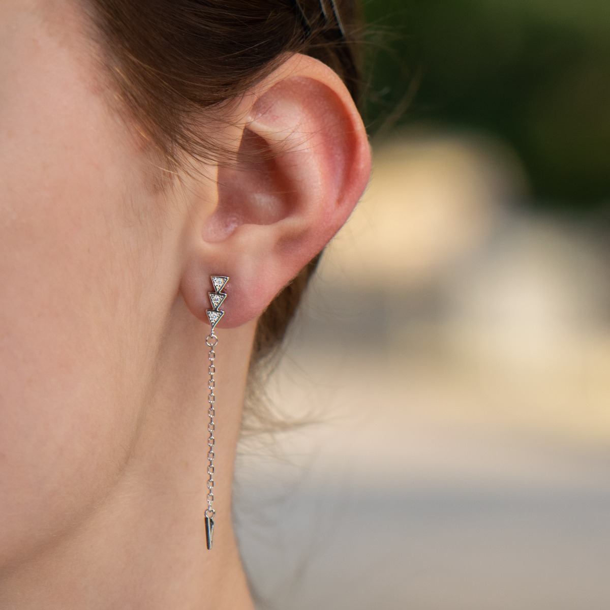 Fine women's earrings in shiny rhodium silver, with a delicate chain ending in a triangular pendant. Pin fastening - comfortable and practical for ladies.