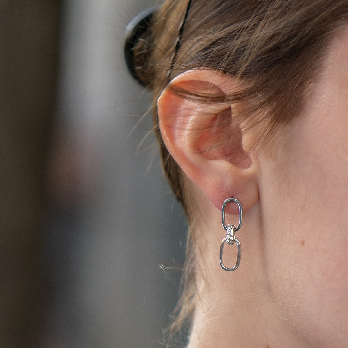 Elegant women's earrings with a dangling pattern in fine rhodium silver and an element with sparkling zircons. With a pin fastening, the earrings are suitable for any style and outfit.