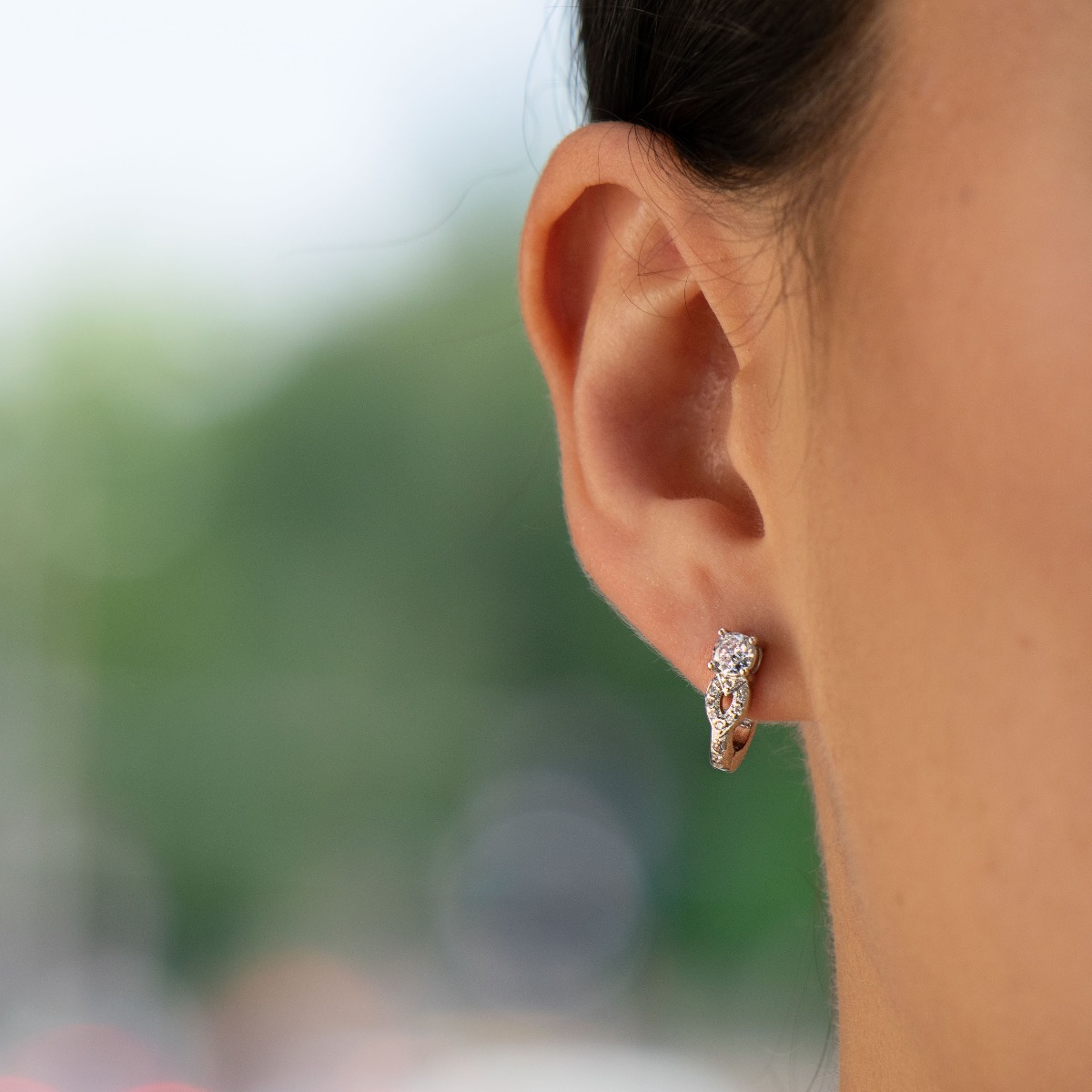 Graceful ladies earrings made of rhodium silver with a comfortable English clasp. The front side of the earrings is shaped like an exquisite flower, carefully crafted from zircons.