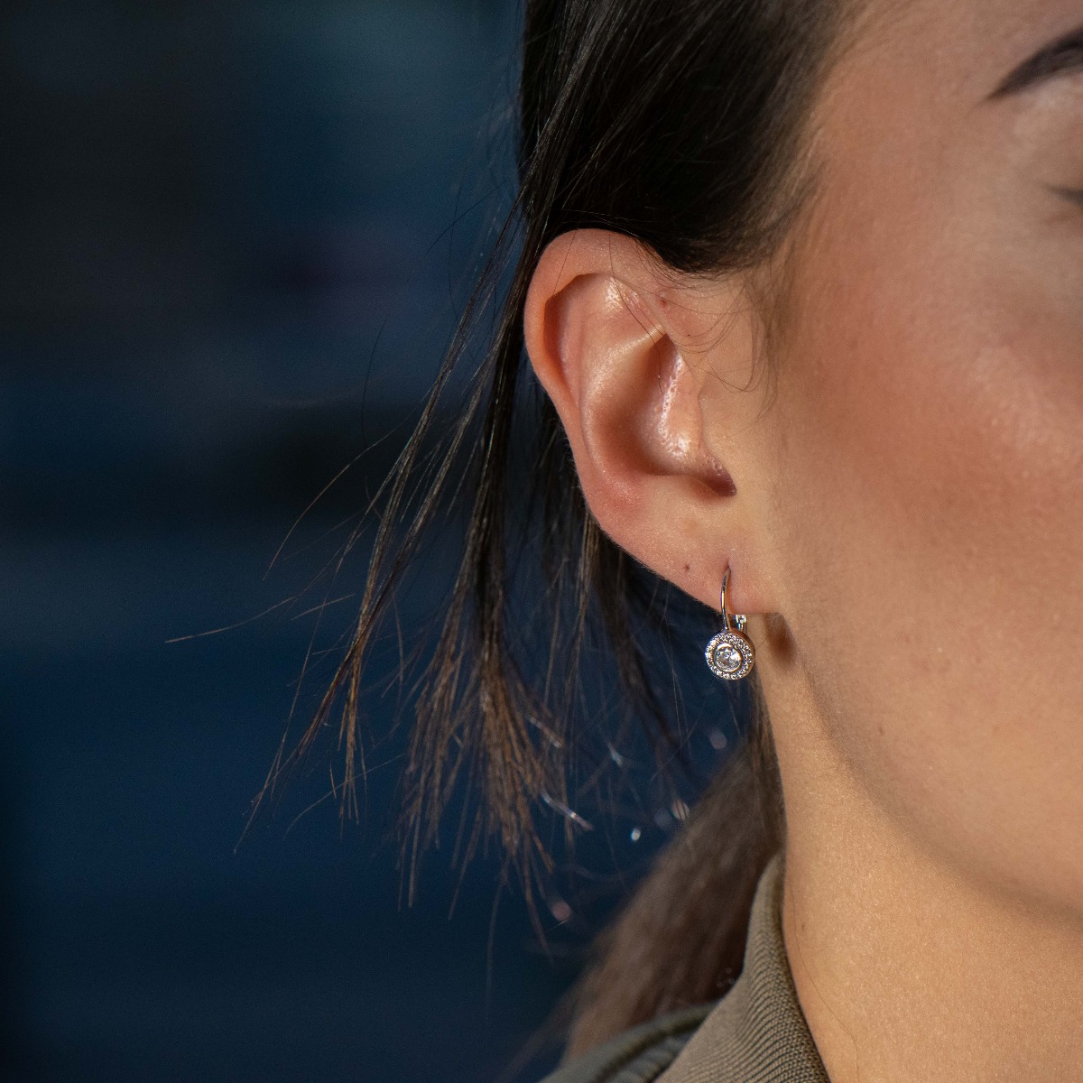 Delicately elegant silver earrings with a willow clasp. Stylishly crafted from a fine combination of rhodium silver with a sparkling central zircon and fine stones arranged in a circle around it.