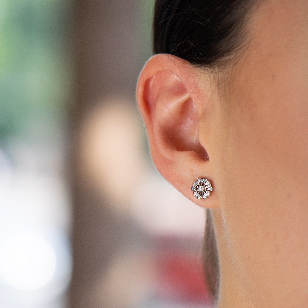 Charming flower shaped soft rhodium silver stud earrings encrusted with zircons and a charming pearl in the center. Pin fastening is comfortable and secure for little and big ladies.