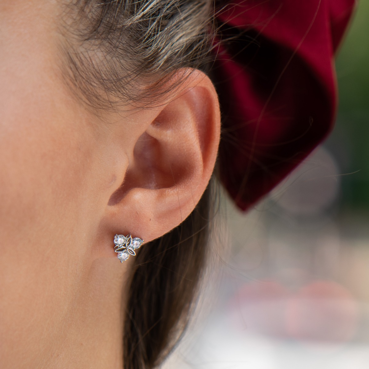 Delicate women's earrings made of fine rhodium silver, with an interesting design layout of a charming flower. Beautiful petals, exquisitely shaped by glittering zircons make this jewelry a desirable gift for any lady. And the pin fastening is a convenien