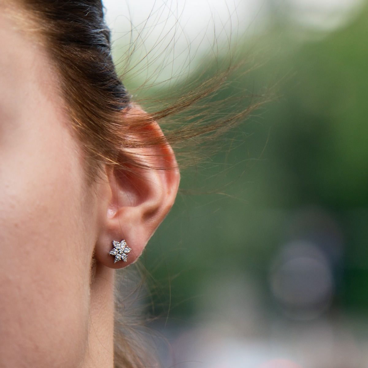 Charming women's earrings, masterfully crafted from fine rhodium silver in the shape of an exquisite flower. The elements are beautifully encrusted with zircons of different sizes that add extra charm to the earrings.