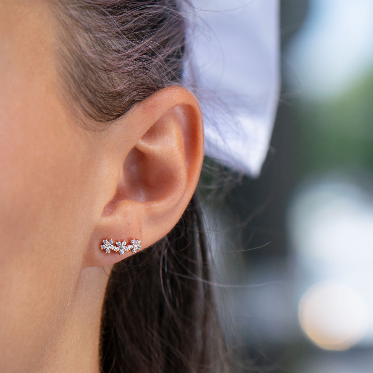 Delicate silver stud earrings with exquisite workmanship entirely in rhodium-plated rose silver. Three small glittering zirconia flowers fascinate with their beauty and style.