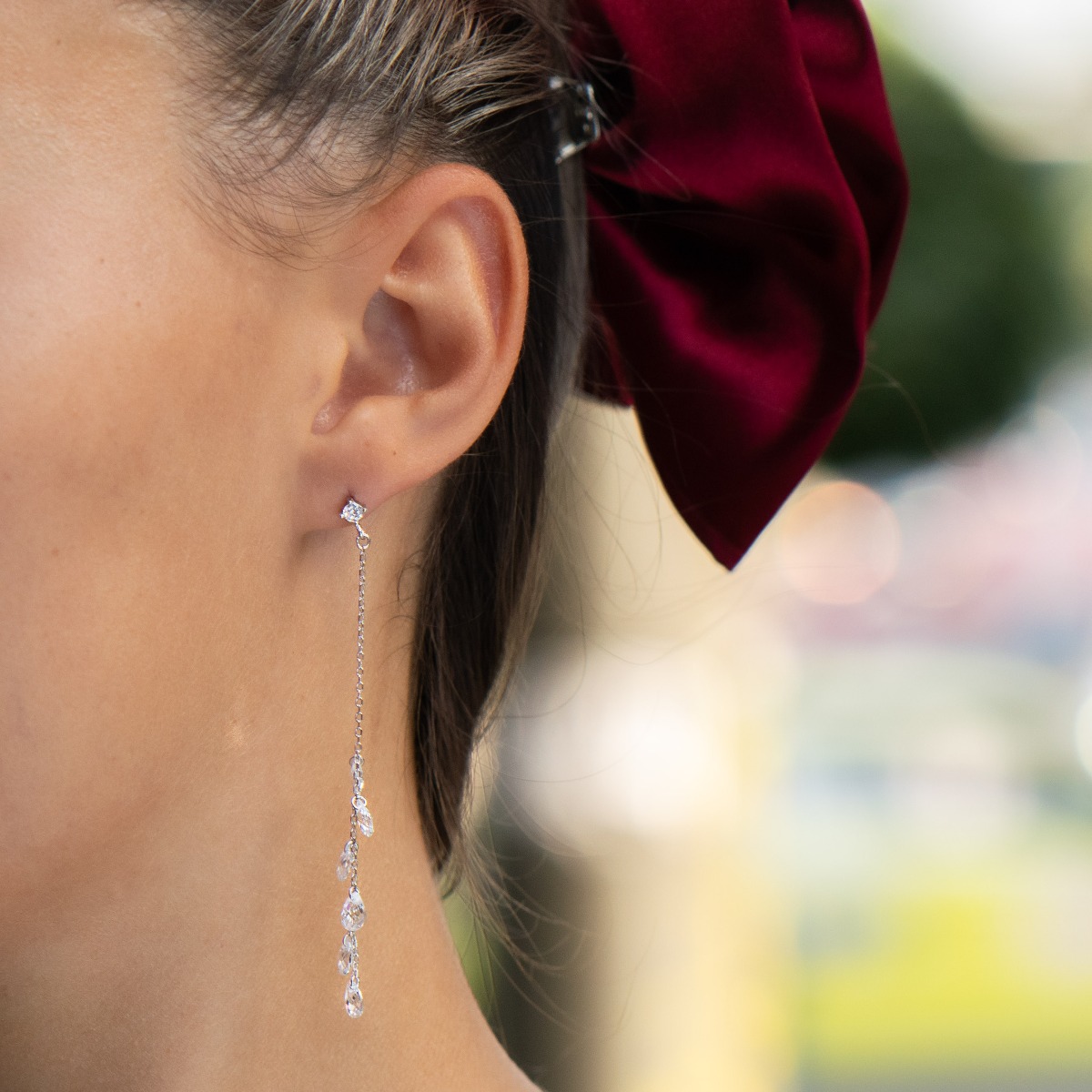 Charming dangling earrings in fine rhodium silver, with a delicate chain decorated with teardrop zircons. Pin fastening - comfortable and practical for ladies.