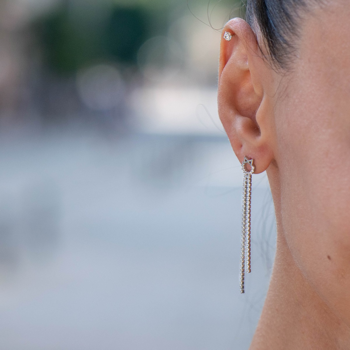 Stylish women's earrings, elegantly formed by two delicate silver chains, completely covered with sparkling zircons. The earrings are fastened with a pin, for greater convenience and security.