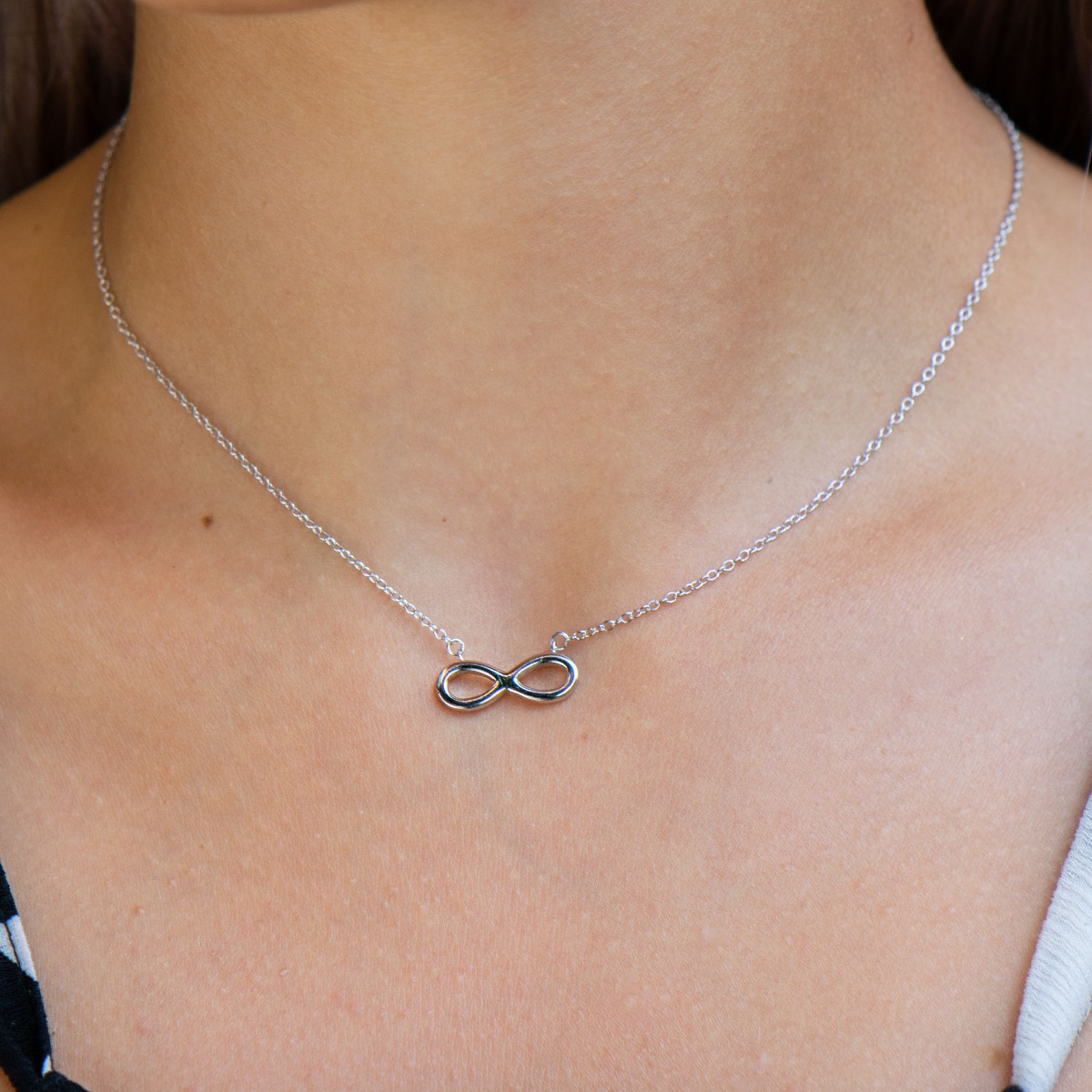 A stylish women's necklace, elegantly crafted from fine rhodium silver as a fine chain holding a simple infinity. The jewelry is suitable for every lady's everyday life.