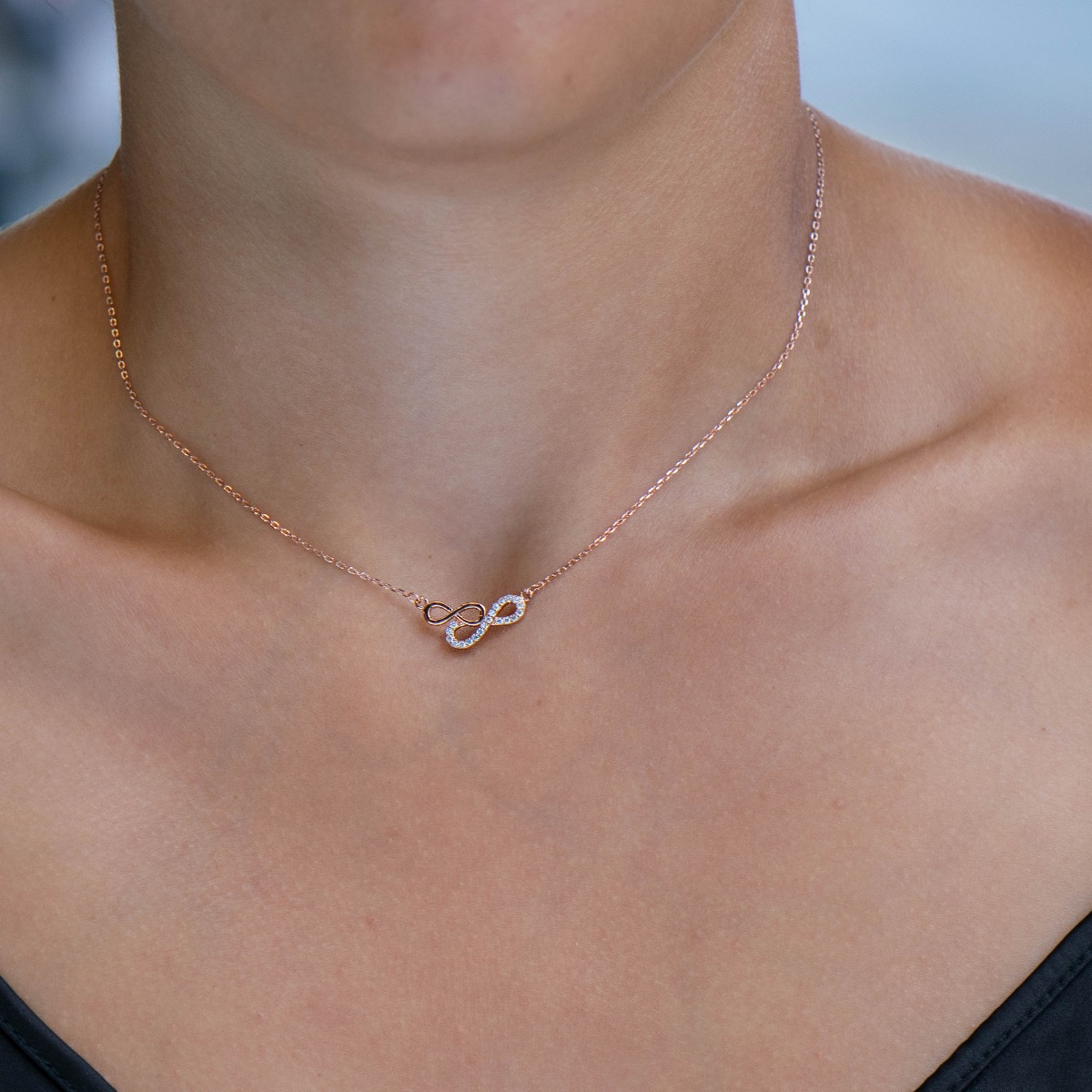 An elegant women's necklace in the shape of gentle infinities, complemented by sparkling zircons and made entirely of spectacular rhodium-plated rose silver.