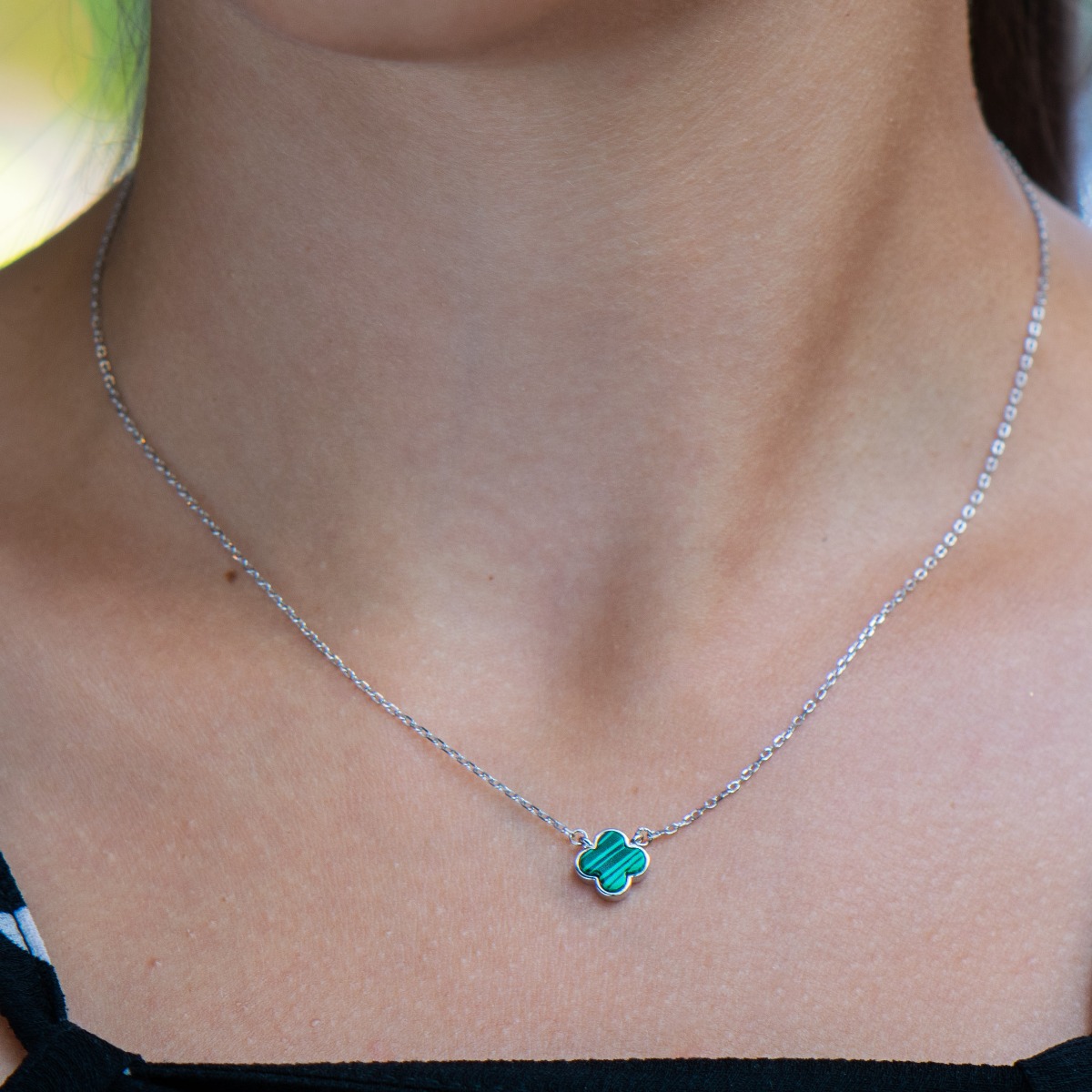 An elegant women's necklace with a simple design of fine rhodium silver, a delicate chain and a beautiful malachite clover.