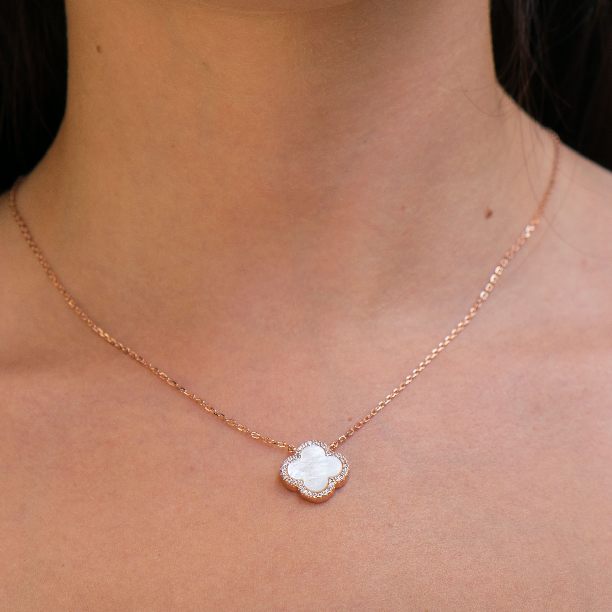 Stylish women's clover shaped necklace in classic rhodium-plated silver and beautiful white mother-of-pearl. A row of dazzling zircons encircles the delicate clover. Suitable jewelry for your everyday life in the office or in nature.