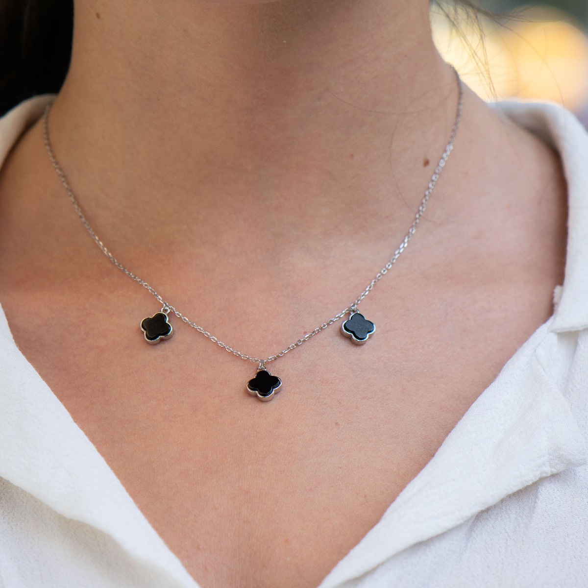 Exquisitely crafted women's necklace from fine rhodium silver, with beautifully shaped charms - clovers from magical onyx. The jewelry is suitable for any lady's casual or formal outfit.