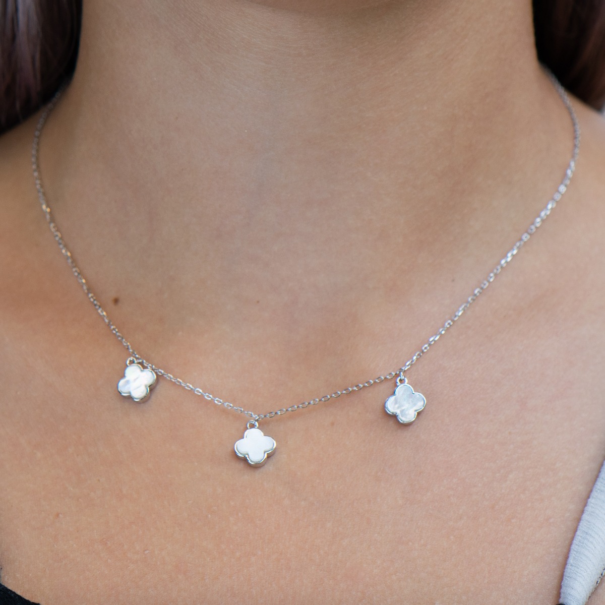 Exquisitely crafted women's necklace of fine rhodium-plated silver, with beautifully shaped pendants - clovers of delightful mother-of-pearl. The jewelry is suitable for any lady's casual or formal outfit.